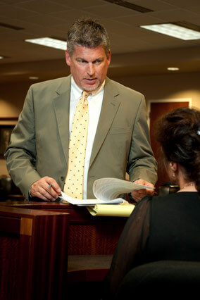 Paul J. Dickman sharing documents with the judge in the court room