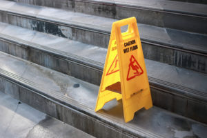 Slippery concrete steps with a yellow warning sign