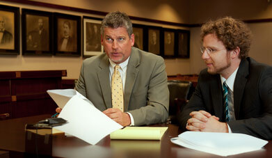 Attorney Paul J. Dickman discussing a case with a client