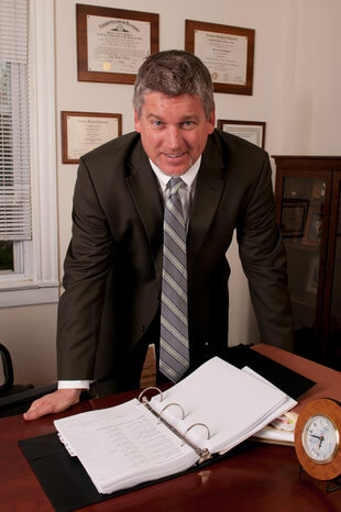 Attorney Paul J. Dickman standing at his desk