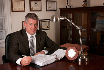 Attorney Paul J. Dickman principal from the Dickman Law Office P.S.C. sitting at his desk