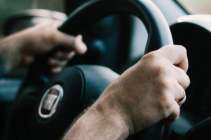 Two hands clutching a steering wheel