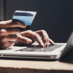 Man using stolen credit card on computer
