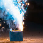Firework igniting on the ground revealing blue sparks