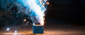 Firework igniting on the ground revealing blue sparks