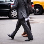 Businessmen jaywalking across a busy city street